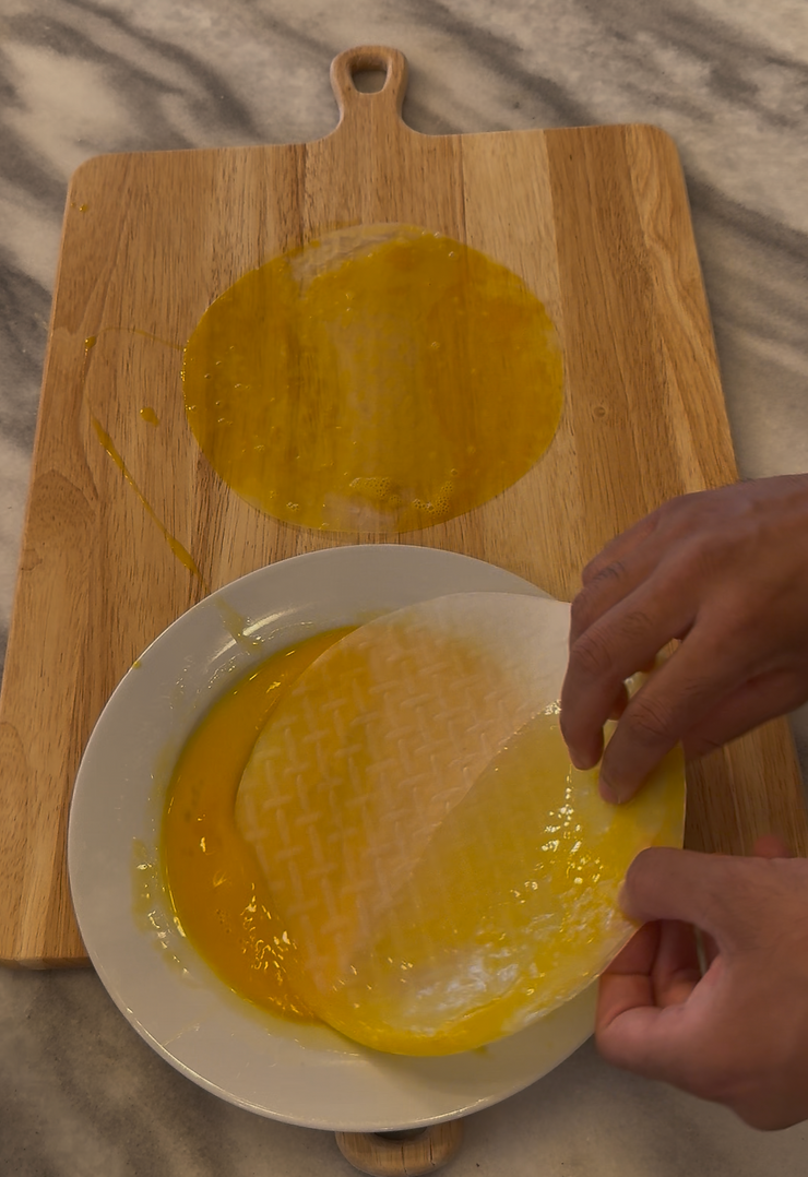 Assembling homemade pizza rolls with rice paper and eggs